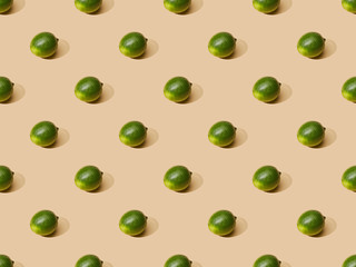 fresh whole limes on beige background, seamless pattern