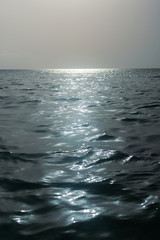 Sea horizon. The rays of the sun on the softly rolling waves of the Caribbean. Glare on the water