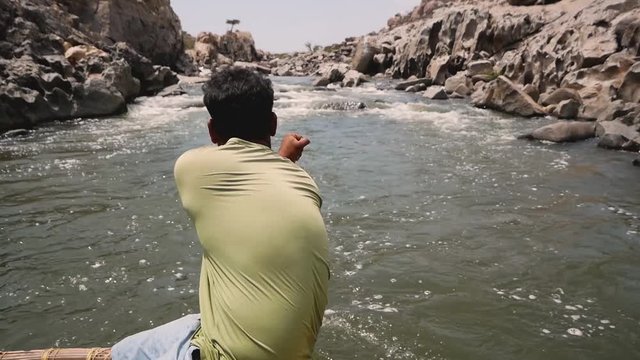 Boatman rowing on the Tungabhadra River in Hampi, Karnataka