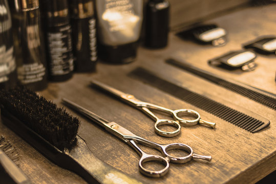 professional scissors and combs lie on a shelf in a hairdresser