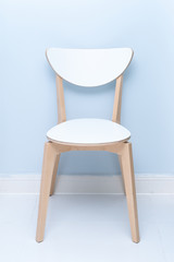 A white wooden backrest chair in a minimalist home. A white wooden dining table and chairs.
