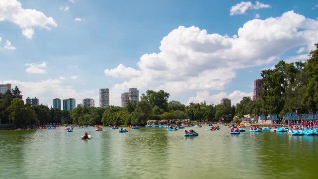 People floating in pedalos on a lake in the city of mexico timelapse