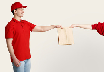 Fast home delivery. Smiling courier gives package