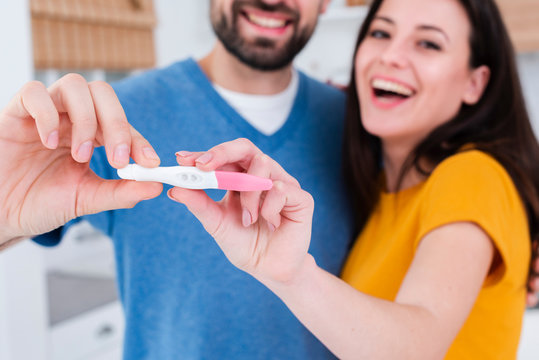 Smiling couple showing off pregnancy test