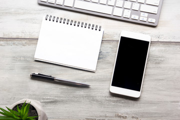 White desk office with laptop, smartphone and other work supplies with cup of coffee. Top view with copy space for input the text. Designer workspace on desk table essential elements on flat lay