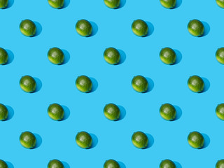 fresh whole limes on blue colorful background, seamless pattern
