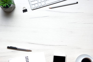 White desk office with laptop, smartphone and other work supplies with cup of coffee. Top view with copy space for input the text. Designer workspace on desk table essential elements on flat lay