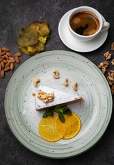 Nut cake with a cup of coffee on a black background