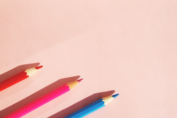 Background of colorful pencils on pink background. Back to school, education and learning concept. Minimalist isometric concept.