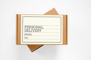 Two cardboard boxes for parcels, one above the other, with blank label written about personal delivery and copy space for any text. Post delivery or courier service concept.