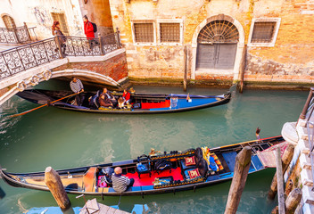 Typical canal with tourist gondolas in Venice in Veneto, Italy