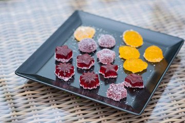Fruit and berry marmalade sweets, jelly sweets on a black plate.