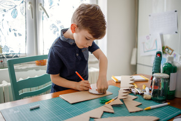 Smiling boy making a cardboard dinosaur costume