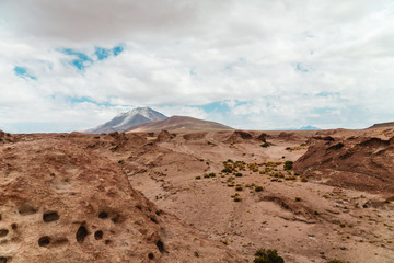 Rocky landscape mountain background. Dry, Barren desert, snowcapped mountains wilderness. Mountain range view. Salt Flats of Uyuni, Bolivia. Copy space, Rocks, blue sky, nature, hiking, sand dust