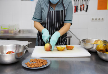 Woman in apron cutting apples for baking pie