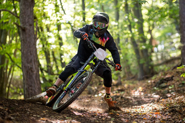 Man on mountain bike rides on trails trough the forest. 