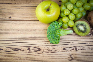 Vegetarian healthy food. Source of protein for vegetarians. Healthy eating: vegetable, apple, broccoli, kiwi, grapes on wooden table.
