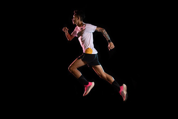 Fototapeta na wymiar Asian man young sprinter runner running in studio on black background