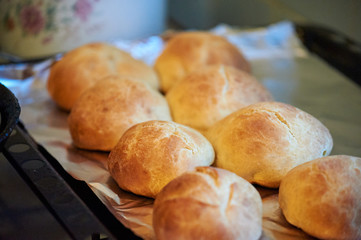 Freshly baked buns on a black tray. Selective focus