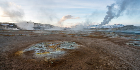 Hverarond geothermal area in Myvatn, Iceland. Steam vents and hot pools, muddy hot soil, sulfur smoke and colorful textures and patterns during blue hour.