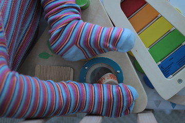 Little baby feet in a wooden baby cot.