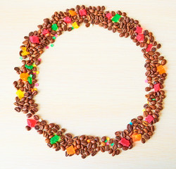 A circle of coffee beans and multi-colored candied fruits. Template. Background