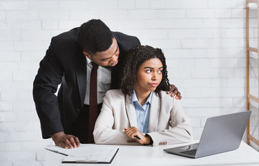 Workplace molestation. Young African american girl harassed by her lustful boss in office. Panorama