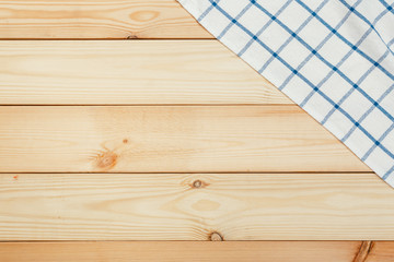 Top view on a wooden table with a linen kitchen towel or textile napkin.
