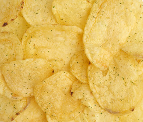 heap of round yellow fried potato chips with dill, food with spice