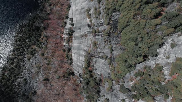 Flying over the rocky mountain cliff of Mount Pinacle in Canada