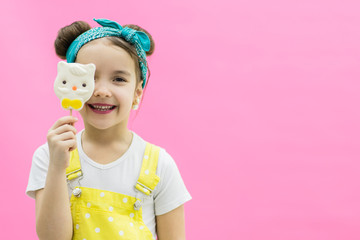 View of little sweet girl hiding behind a lollipop.
