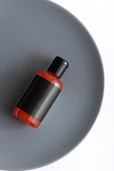 Dark bottle of skincare cosmetic product on white background