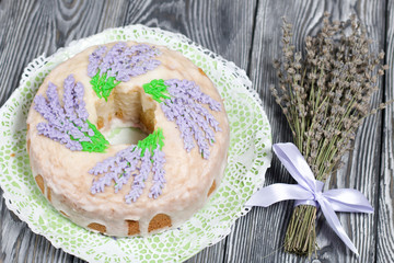 Lavender Cupcake. Sugar coated. Decorated with lavender glaze flowers. Near a bouquet of lavender.