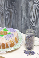 Lavender Cupcake. Sugar coated. Decorated with lavender glaze flowers. Near the bank with lavender inflorescences.