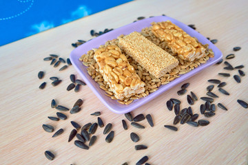 Peanut and sesame gozinaki on a lilac rectangular plate
