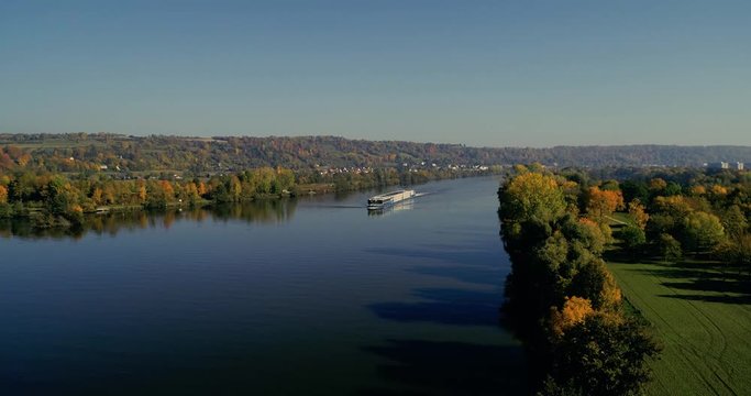 Drohnenaufnahme über der Donau im Herbst mit Fokus auf ein Schiff