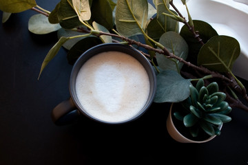 cup of coffee near green plant 