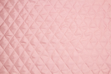 Quilted fabric. The texture of the blanket. Red textile