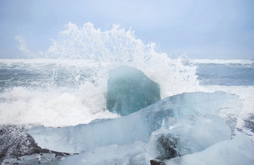 wave splashes over ice pieces