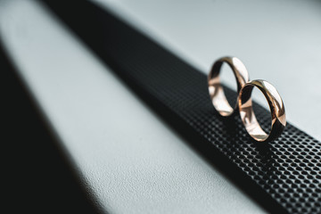 Close up of wedding rings on a black leather belt