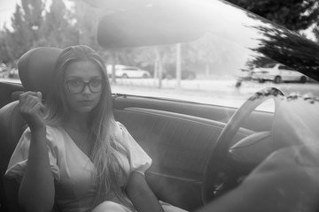 Beautiful girl driving a car.Portrait of the beautiful young girl on nature with cabriolet.Blonde...