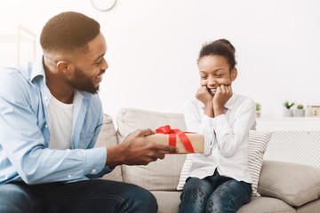 African Father Giving Birthday Present For Daughter