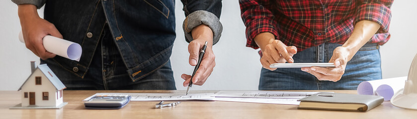 Engineer or architect teamwork working on construction project with building model and blueprint in office. Construction concept.