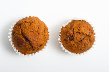 pair of chocolate muffins on white table
