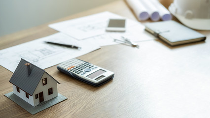 Engineering or Architect tools, blueprint and house model on table in office. Construction concept.