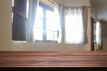 Empty wooden desk space over curtain and window background for product presentation.