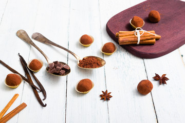 chocolate truffles, cocoa powder, broken dark chocolate on white wooden