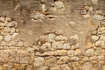 seamless horizontal texture of an old wall made of rubble stone, brown sandstone, with the remains of cracked old plaster, a blank for the designer, wallpaper