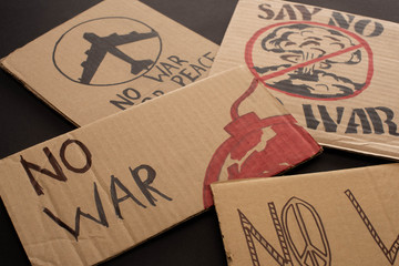 cardboard placards with no war lettering on black background