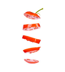 Pieces of chopped red sweet tomato flying in space on a white background isolate.